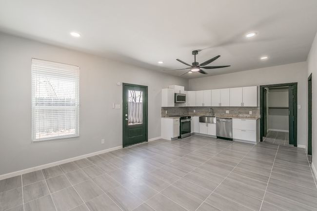 Kitchen featuring a ceiling fan, white cabinetry, tasteful backsplash, stainless steel appliances, and recessed lighting | Image 4