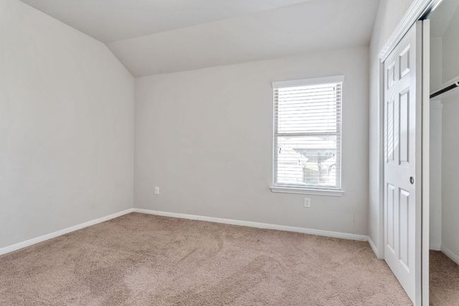 Unfurnished bedroom with light carpet, baseboards, lofted ceiling, and a closet | Image 28