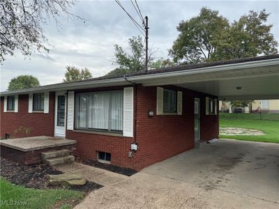 View of front of property featuring a carport and a front yard | Image 1