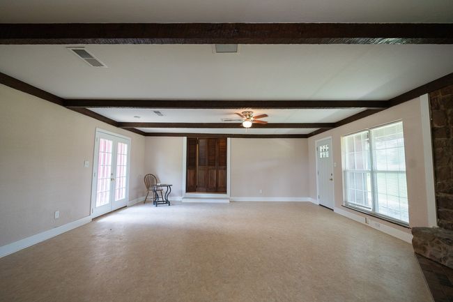 Unfurnished living room featuring beamed ceiling and a ceiling fan | Image 7