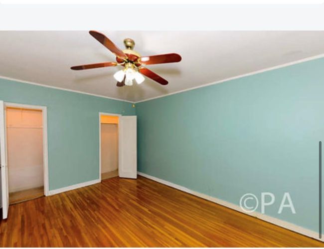 Unfurnished bedroom featuring a ceiling fan, baseboards, ornamental molding, and wood finished floors | Image 4