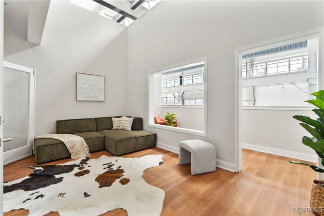 Living room with healthy amount of natural light, wood finished floors, and a high ceiling | Image 20