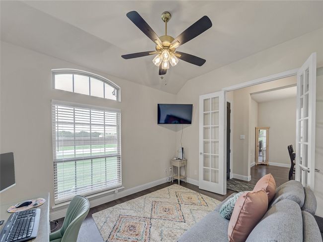 Office featuring french doors, healthy amount of natural light, a ceiling fan, wood finished floors, and lofted ceiling | Image 9