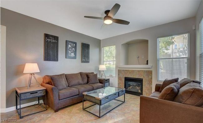 Living room featuring a tile fireplace, plenty of natural light, a ceiling fan, and baseboards | Image 8