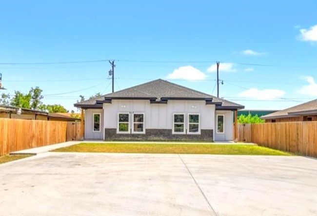 View of front facade with a front yard, a fenced backyard, and a patio | Image 12