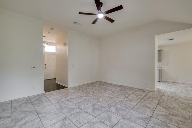 Spare room with ceiling fan, vaulted ceiling, and light tile patterned floors | Image 8