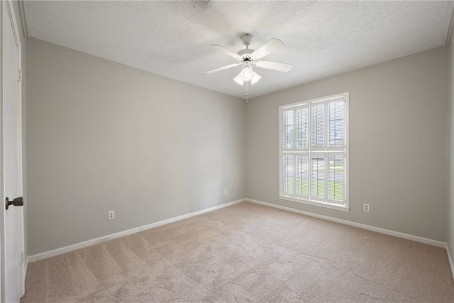 Empty room featuring a textured ceiling, carpet floors, a ceiling fan, and baseboards | Image 16
