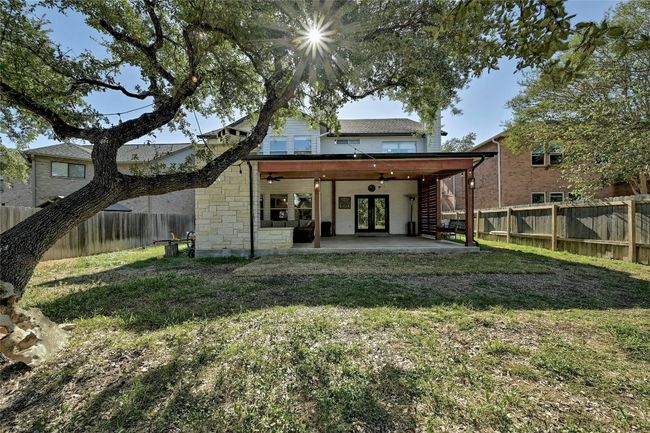 Rear view of property featuring a fenced backyard, a patio, french doors, and stone siding | Image 29
