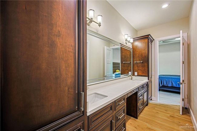 Ensuite bathroom featuring double vanity, wood finished floors, and recessed lighting | Image 29