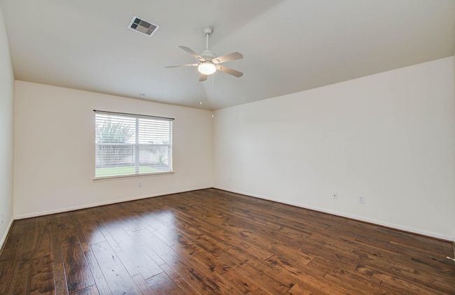 The primary bedroom features the same Hickory wood flooring, high ceilings, and can accomodate all the furnishings. | Image 20