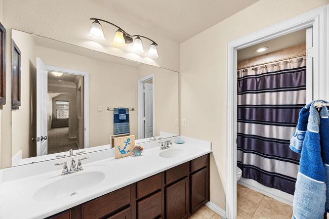This hallway bath upstairs is shared for the other two guest bedrooms. It has double sinks, plenty of storage and a tub/shower combo. | Image 30