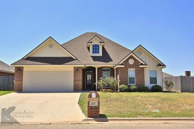 View of front facade with a garage and a front lawn | Image 1