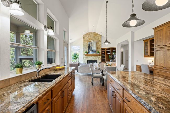 Bright and functional, the kitchen enjoys natural light through windows overlooking the screened porch. A versatile 6'+ island offers generous storage for large appliances and features plenty of drawers—perfect for prep, serving, or casual dining. | Image 13