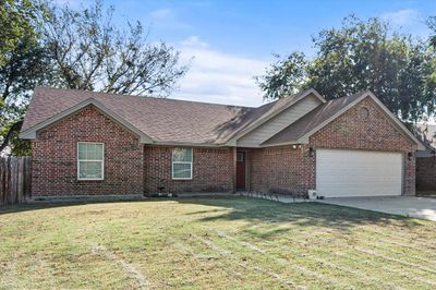 Ranch-style home with a front yard and a garage | Image 2