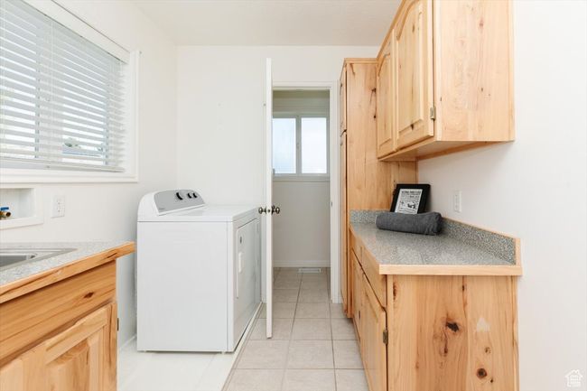 Laundry room with washer / clothes dryer, light tile patterned floors, and cabinet space | Image 41