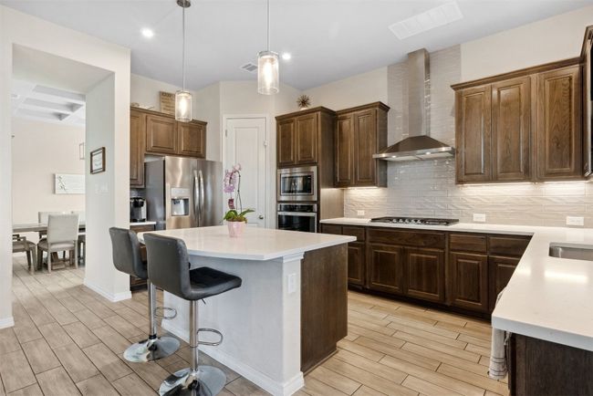 With stainless steel appliances, under-cabinet lighting, and a dry bar, this kitchen is ready for your next gathering | Image 11