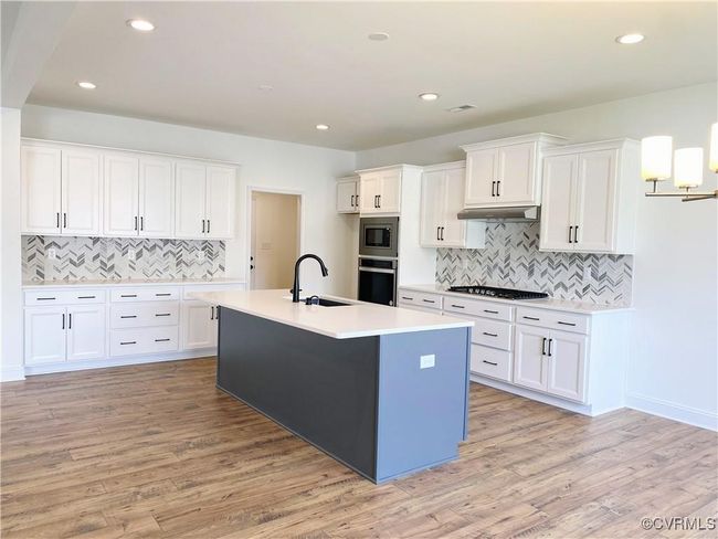 Kitchen with a sink, appliances with stainless steel finishes, backsplash, white cabinetry, and recessed lighting | Image 32