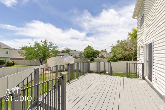 Wooden terrace with a fenced backyard, a storage unit, and a residential view | Image 23