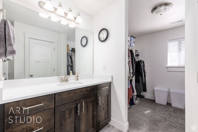Bathroom featuring visible vents, baseboards, a walk in closet, and vanity | Image 19
