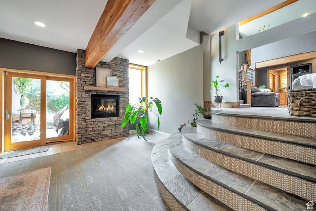 Interior space featuring baseboards, beam ceiling, recessed lighting, a fireplace, and wood finished floors | Image 23