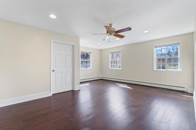 Empty room with plenty of natural light, a ceiling fan, wood finished floors, baseboards, and recessed lighting | Image 20