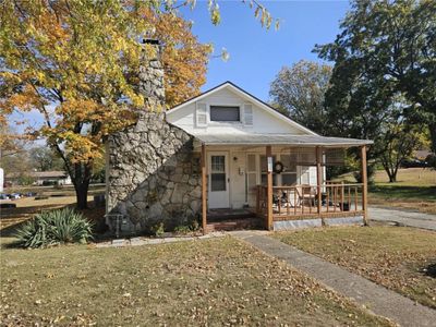 Bungalow-style home with covered porch and a front yard | Image 1