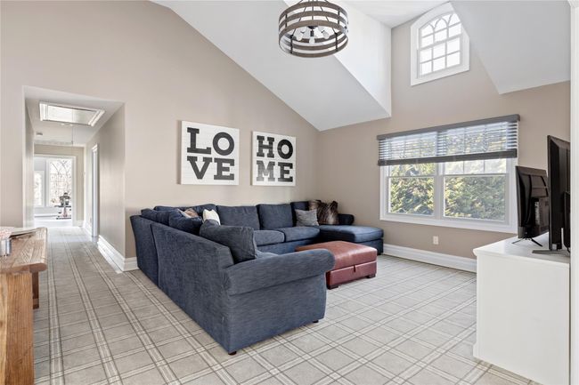 Living room with light carpet, baseboards, and high vaulted ceiling | Image 41