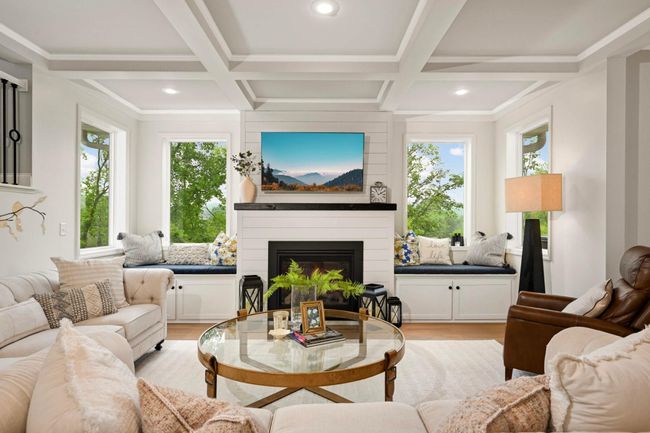 Fireplace with shiplap surround flanked by windows and built-in cabinetry. | Image 11