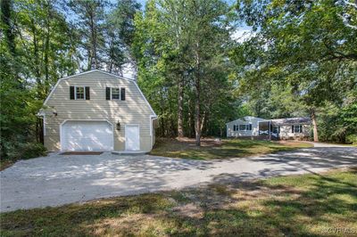 View of side of home featuring a garage and a lawn | Image 1