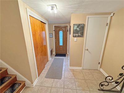 Foyer features a guest closet, drop off area for coats and back packs, and a 1/2 bath. | Image 2