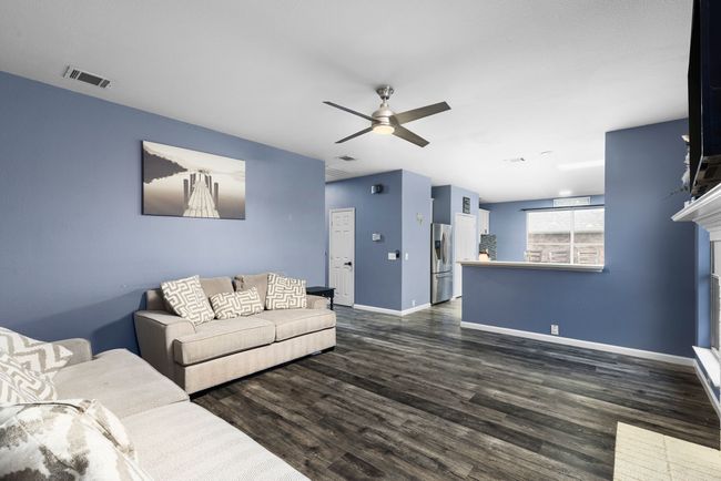 Living room featuring ceiling fan, dark wood-type flooring, and a brick fireplace | Image 13