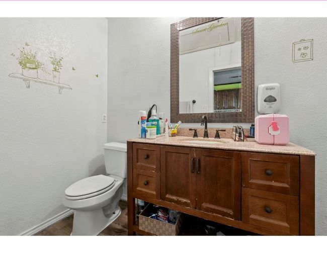 Bathroom featuring a textured wall, vanity, and wood finished floors | Image 33