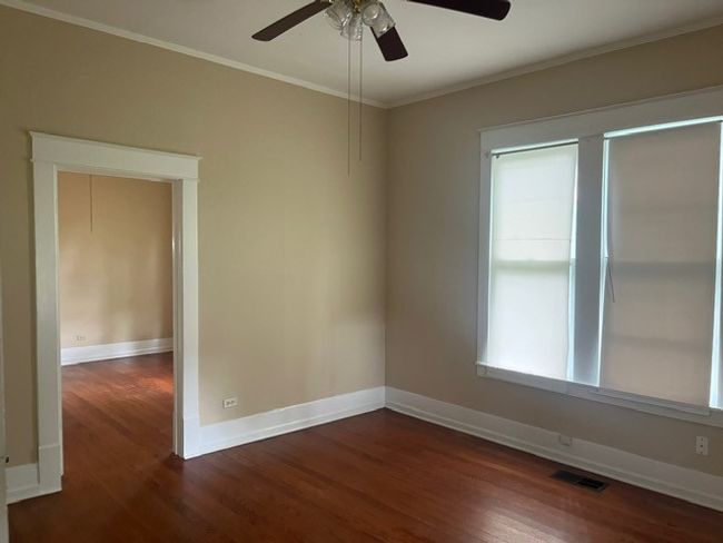Spare room featuring dark wood-type flooring, a ceiling fan, and ornamental molding | Image 20
