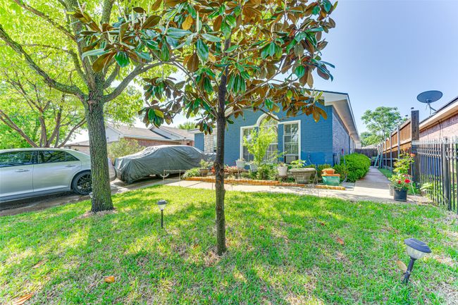 View of front of house featuring brick siding, a front lawn, and fence | Image 4