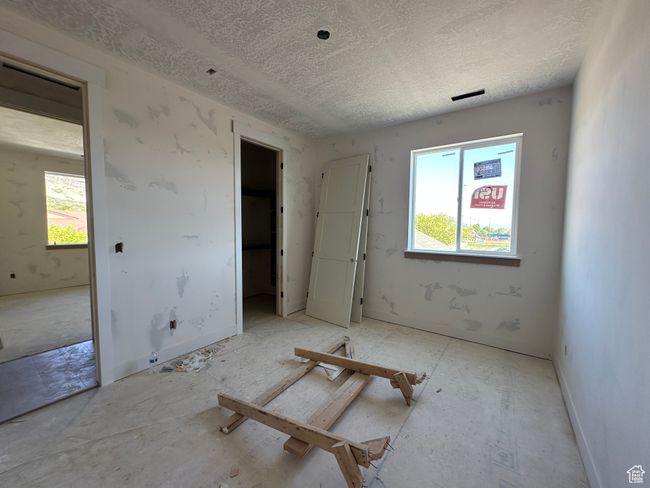 Unfurnished bedroom with a textured ceiling | Image 10