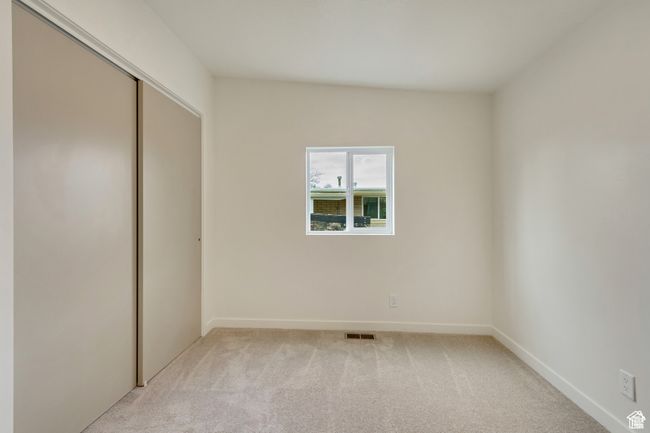 Unfurnished bedroom featuring a closet, baseboards, visible vents, and light colored carpet | Image 22