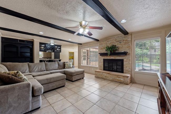 The fireplace and view of the back yard provide a lovely focal point. | Image 9