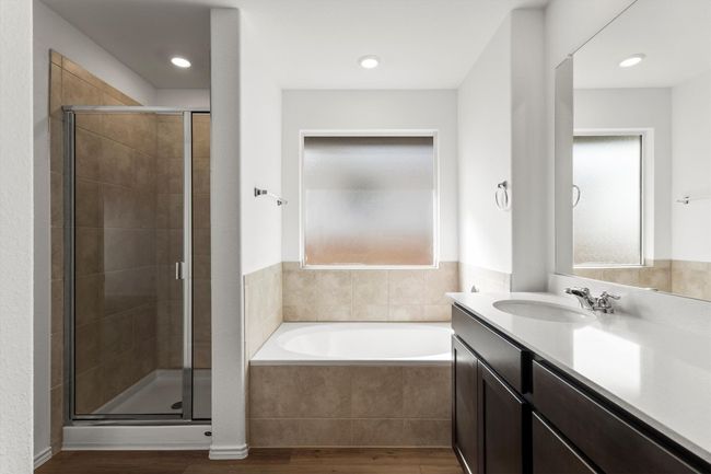 Full bathroom featuring a garden tub, wood finished floors, vanity, and a stall shower | Image 16