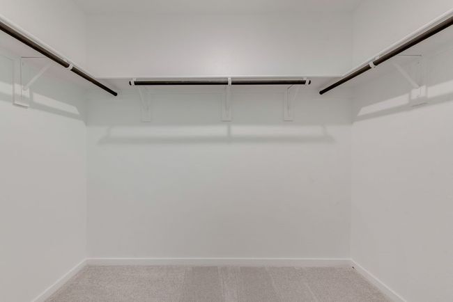 Spacious closet featuring light colored carpet | Image 23