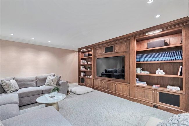 Carpeted entertainment room with stunning built-ins and recessed lighting. | Image 22