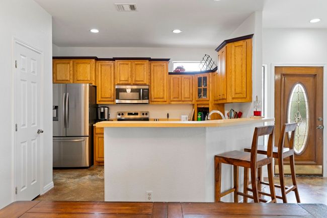 Stainless steel style and a large breakfast bar make this kitchen a practical and polished gathering spot. | Image 12