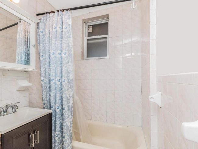 Bathroom with tile walls, vanity, and shower / bath combo | Image 6