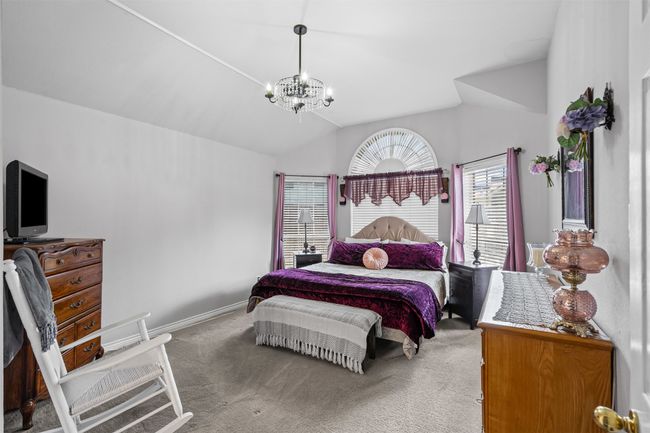 Bedroom with carpet, a chandelier, vaulted ceiling, and baseboards | Image 12