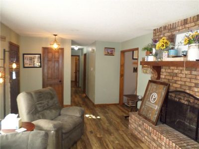 Living room featuring a fireplace and dark hardwood / wood-style flooring | Image 3