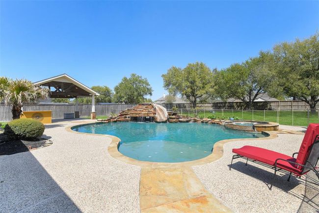 Your summer stay-cation! Large pool with child safety gate, slide, grotto, water falls, spa. Plenty of space for lounge chairs and parties. | Image 37