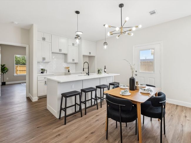 Dining room with light wood finished floors, baseboards, visible vents, and a chandelier | Image 6