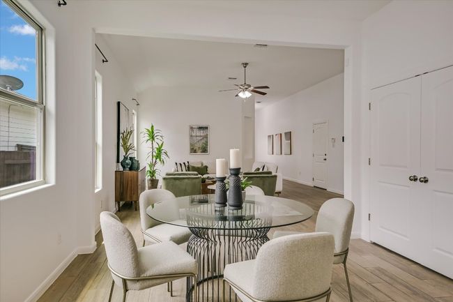The dining space is tucked conveniently between the open living room and kitchen for ultimate convenience. | Image 7