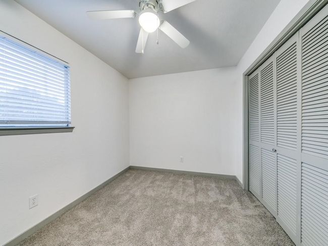 Unfurnished bedroom with light carpet, a closet, baseboards, and ceiling fan | Image 11