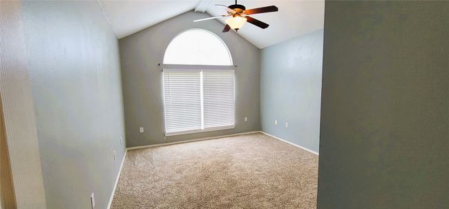 Carpeted spare room with a ceiling fan, baseboards, and vaulted ceiling | Image 4