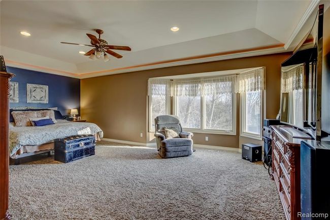 Large master bedroom with sitting area, uplighting, and tray ceiling | Image 24